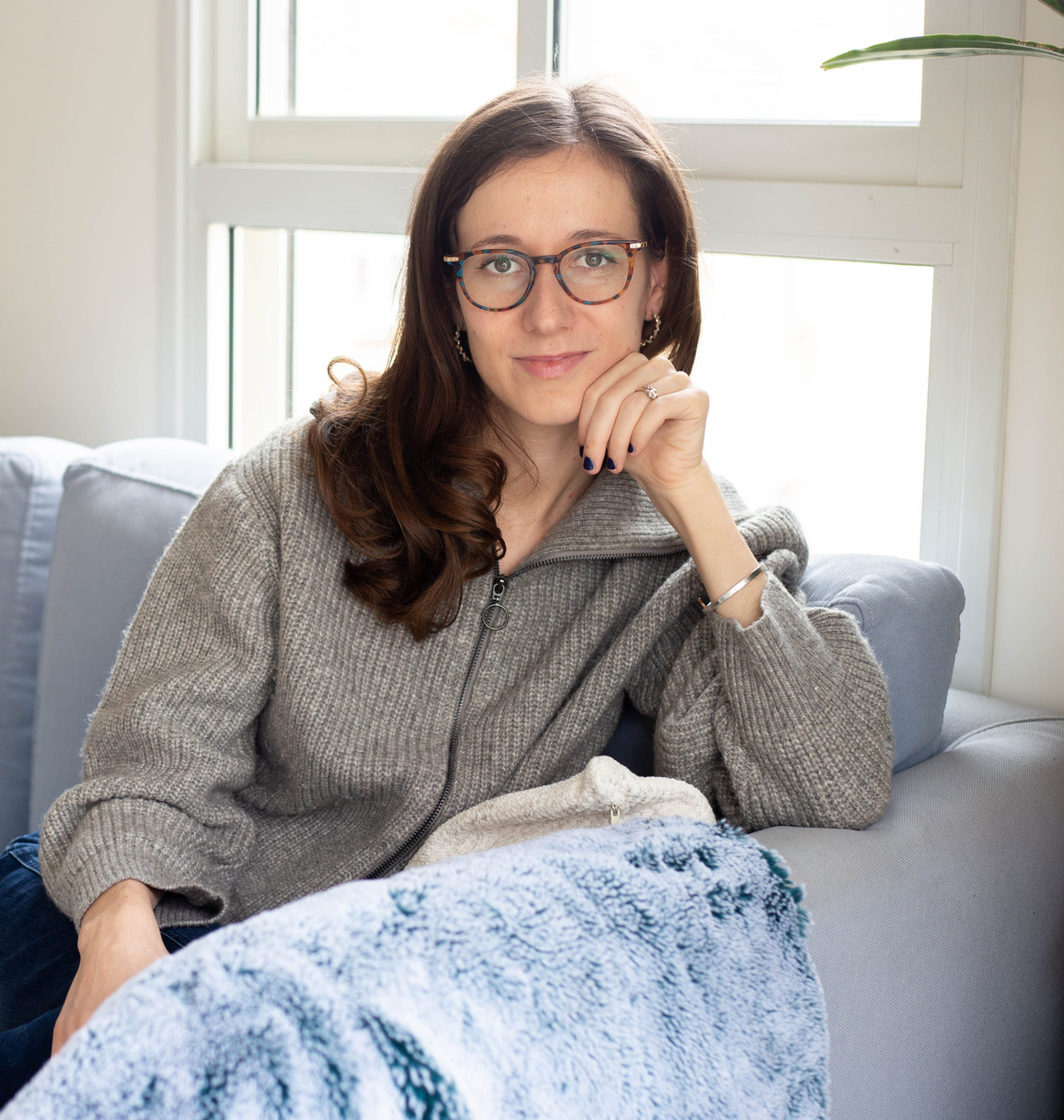 Sara Royf sitting on a couch and looking at the camera
